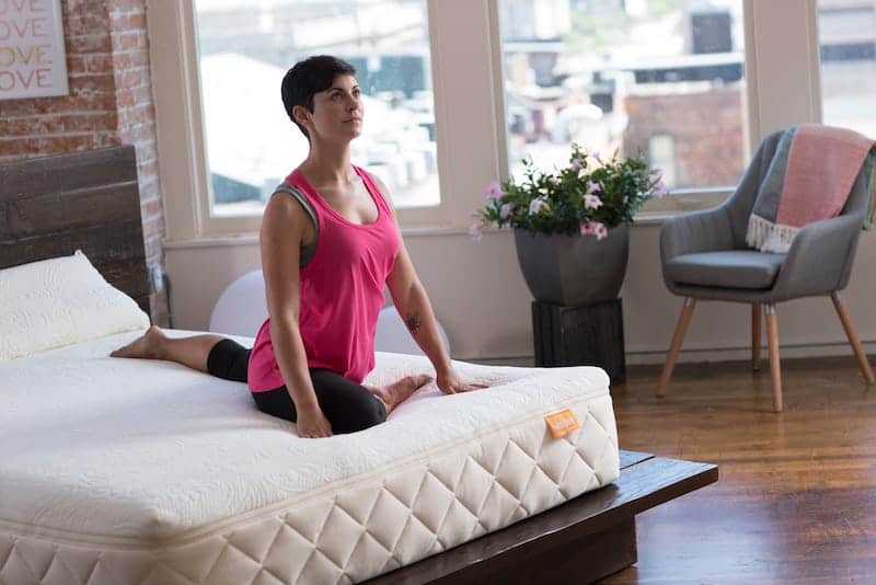 Woman doing a yoga stretch on a Happsy organic mattress