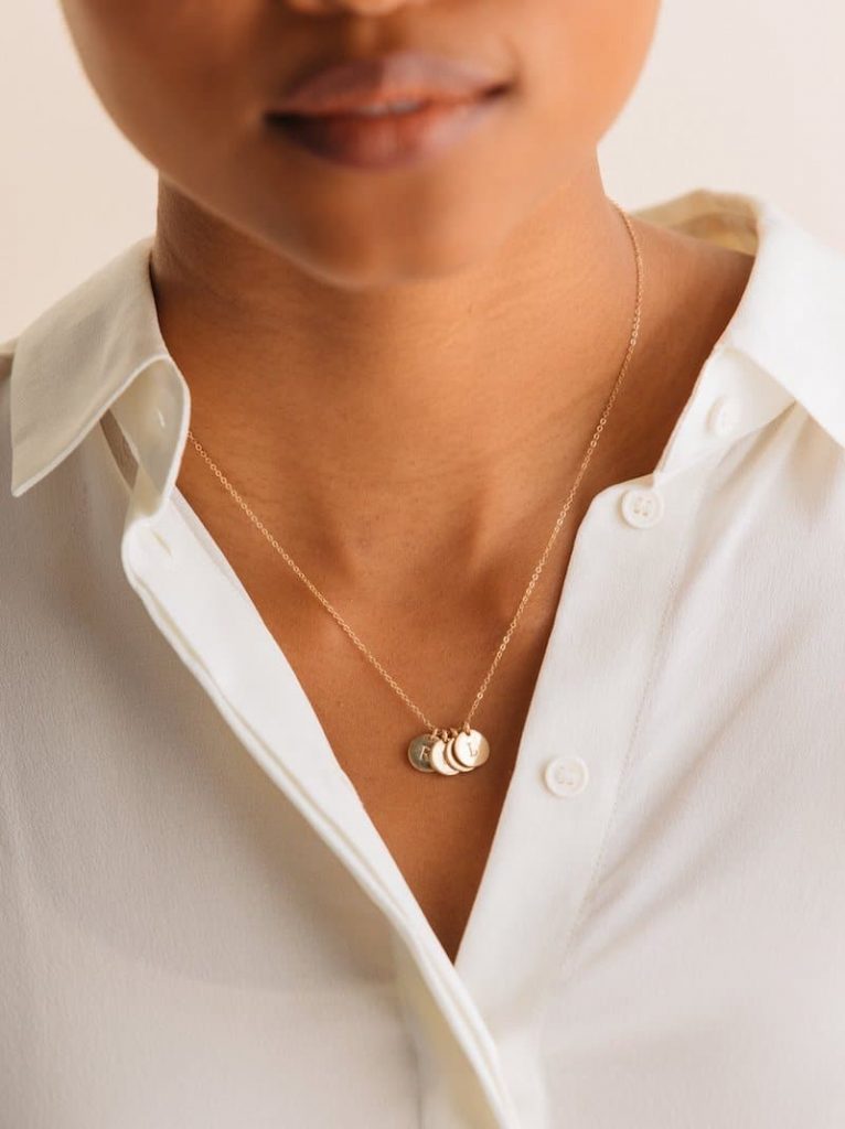 woman in a white shirt wearing Able pendant and chain
