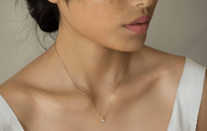woman wearing Gjenmi gold solitaire necklace made of recycled gold 