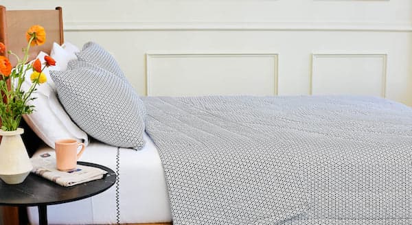 grey colored Circle Round Quilt on a bed, with pillow in the same pattern