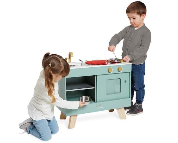 little girl and boy playing with a wooden kitchen set