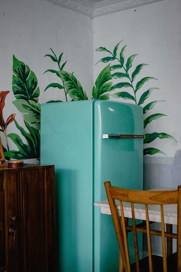 partial view of old green refrigerator in a dining room