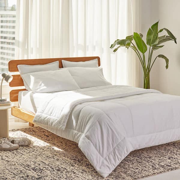 white down alternative comforter on a bed in a sunlit bedroom