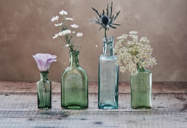 four recycled perfume bottles used as flower vases