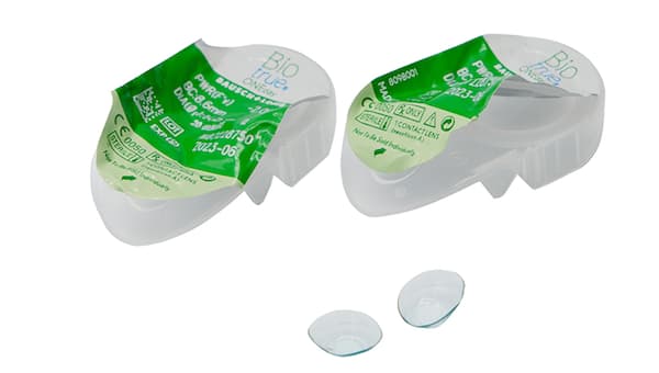 two used contact lenses and their blister packs