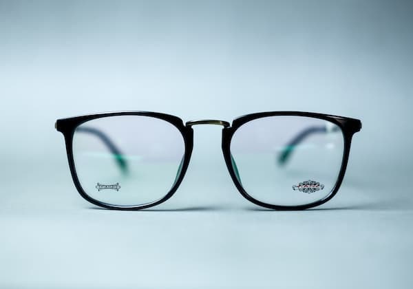black-framed eyeglasses against a blue background