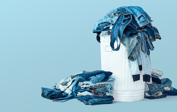 a pile of denim fabrics in a bin, ready to be recycled