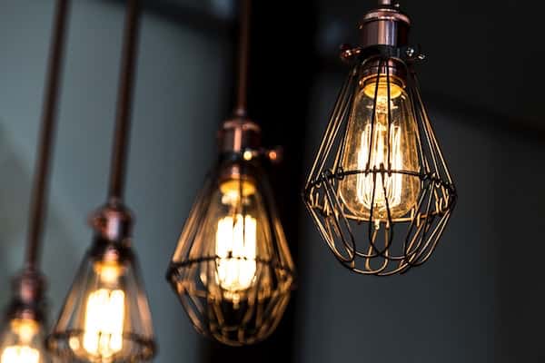 industrial grunge lamps hanging from the ceiling with LED bulbs in them