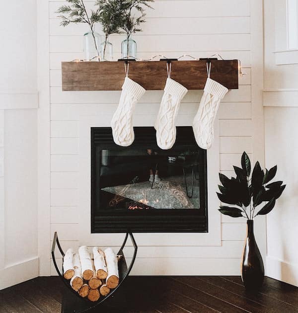 cosy view of a fireplace, stockings and wooden logs