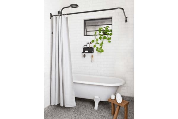 Nebia's water-repellent shower curtain hanging from black bathroom fixtures, around a white bathtub