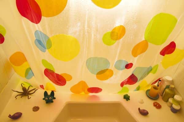 view of a colorful PVC shower curtain from inside the bathtub