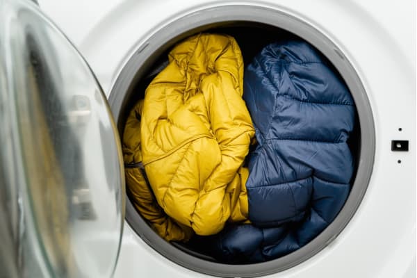two puffer jackets inside a front-loading washing machine
